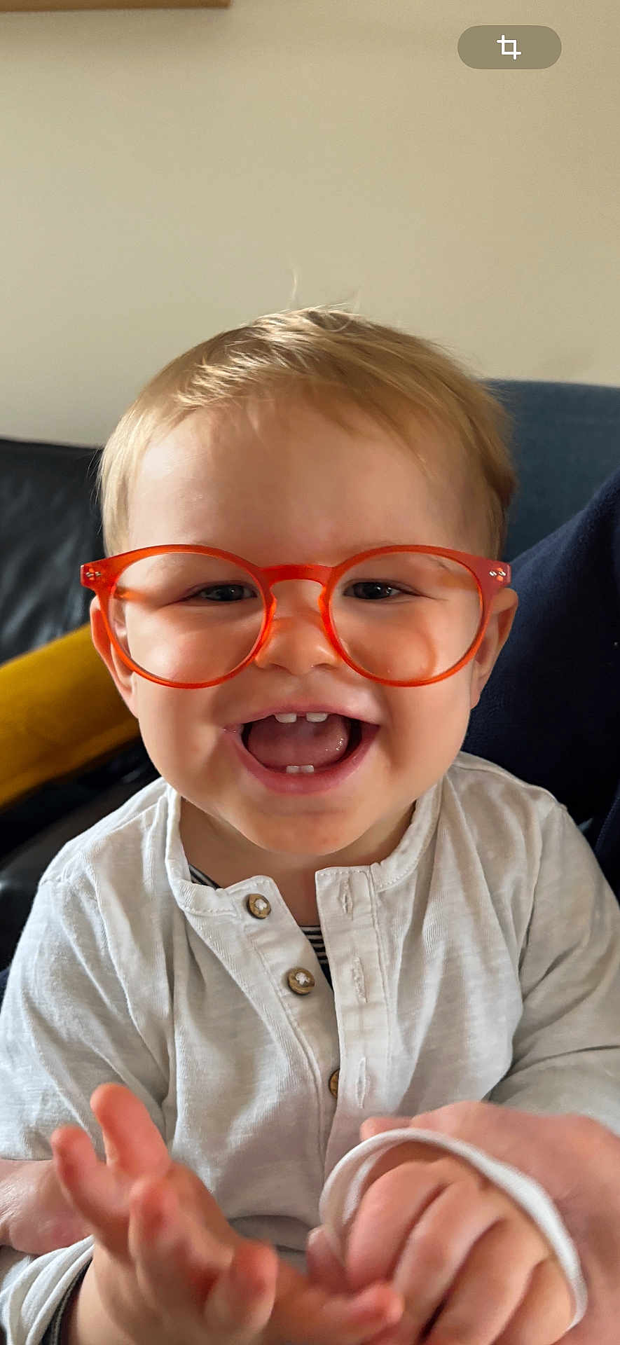 Leo participe au concours pour gagner de l'argent avec cette photo : toddler, child, glasses, orange_glasses, happy, smiling, indoor, portrait, baby, clapping, hands, face, cute, person, white_shirt, buttoned_shirt, short_hair, light_skin, seated, cozy