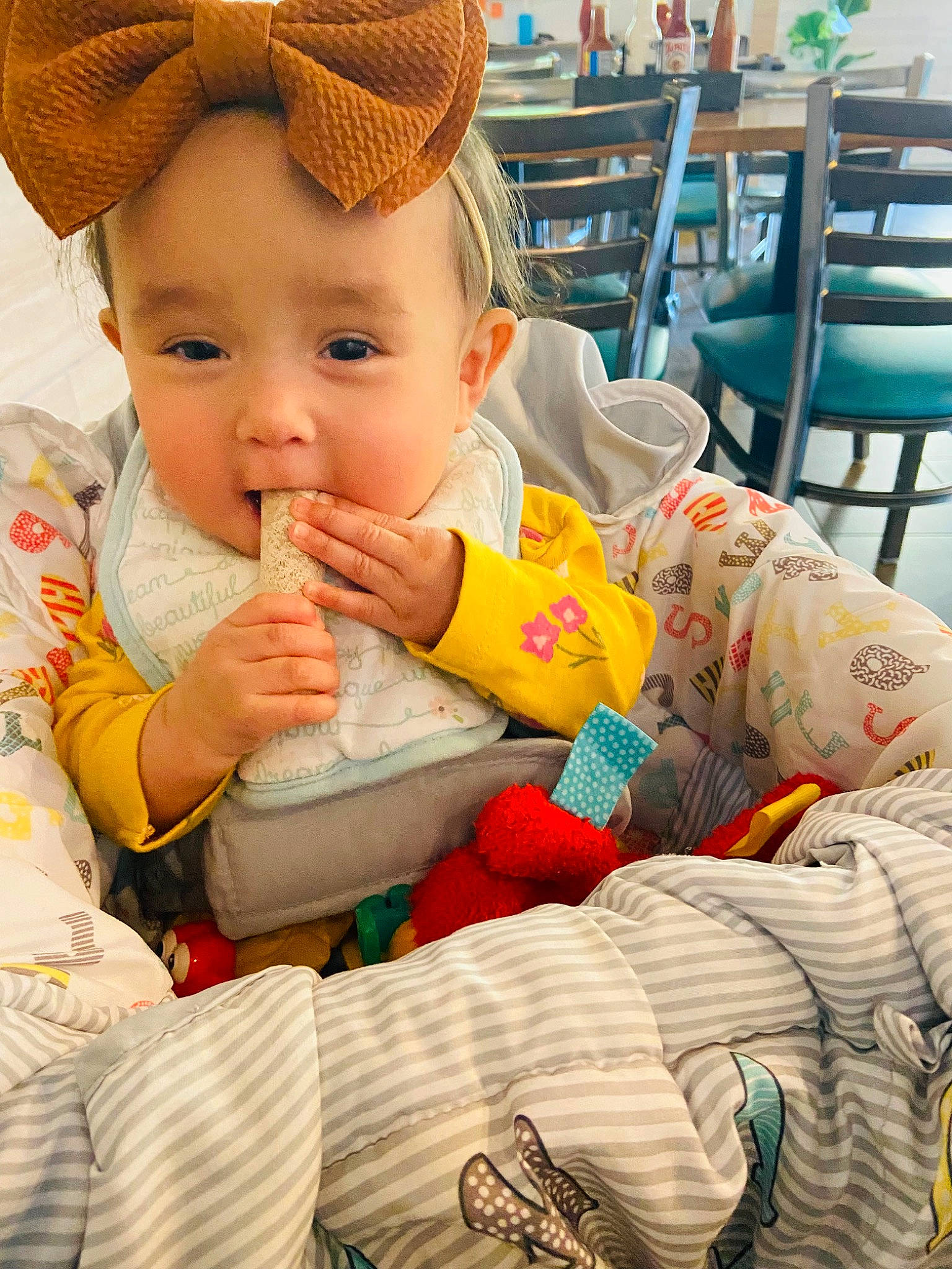 Emily is registered to the contest to win money with this photo: baby, baby_toddler_clothing, cap, chair, child, comfort, fashion_accessory, finger, fun, happy, hat, lap, leisure, linens, person, product, sharing, sitting, skin, textile