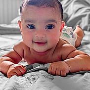 Aairah joined the competition — help win amazing prizes! baby, bed, child, closeup, cute, diaper, eyes, face, hand, happy, indoors, infant, lying_down, person, portrait, skin, smiling, soft_light, tummy_time, young
