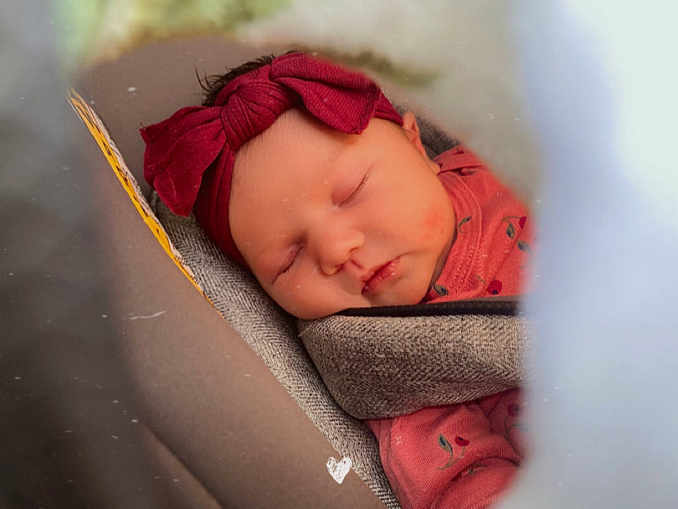 Riley is registered to the contest to win money with this photo: arm, baby, baby_products, baby_sleeping, cheek, chin, comfort, eyebrow, face, hand, happy, head, headwear, human_body, linens, lip, mouth, nose, person, pink