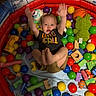 Lucas joined the competition — help win amazing prizes! toddler, child, ball_pit, inflatable, toys, balls, wooden_blocks, plush_toy, colorful, playpen, indoor, happy, smiling, casual_clothing, shorts, black_tshirt, green_plush, orange_basketball, raised_arms, playtime