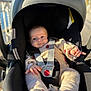 baby, infant, car_seat, seat_harness, buckle, pacifier, stroller, blanket, knit_clothing, hands, eyes, smile, portrait, closeup, sunlight, shadow, outdoors, railings, candid, soft_texture