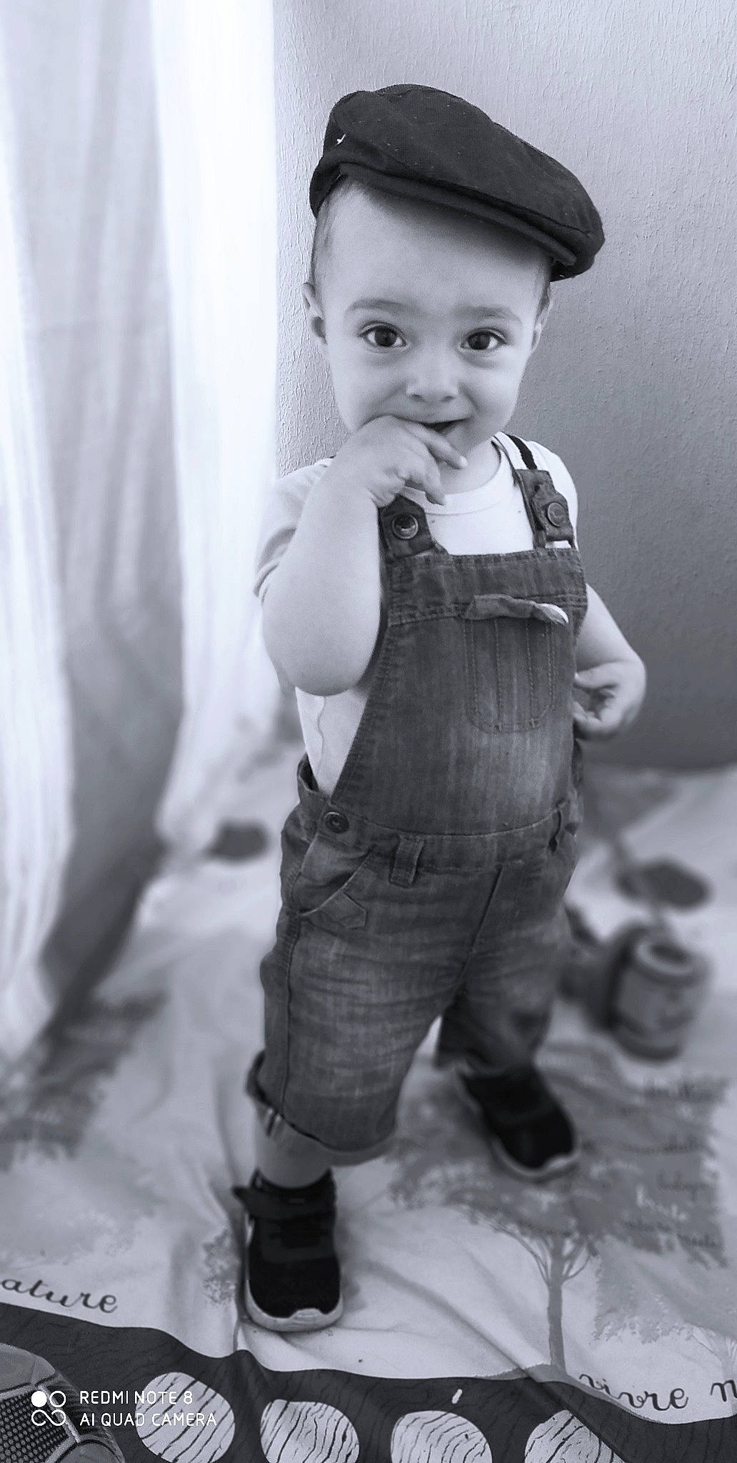 Mathys participe au concours pour gagner de l'argent avec cette photo : baby, baby_toddler_clothing, black_and_white, child, curtain, eye, face, flash_photography, gesture, happy, hat, leg, monochrome, monochrome_photography, person, sleeve, standing, style, toddler, vintage_clothing