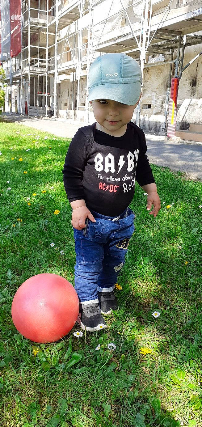 Mathys participe au concours pour gagner de l'argent avec cette photo : baby_toddler_clothing, baseball_cap, cap, child, fun, grass, green, happy, headwear, helmet, jeans, joy, leisure, people_in_nature, person, photograph, pink, plant, shorts, sleeve