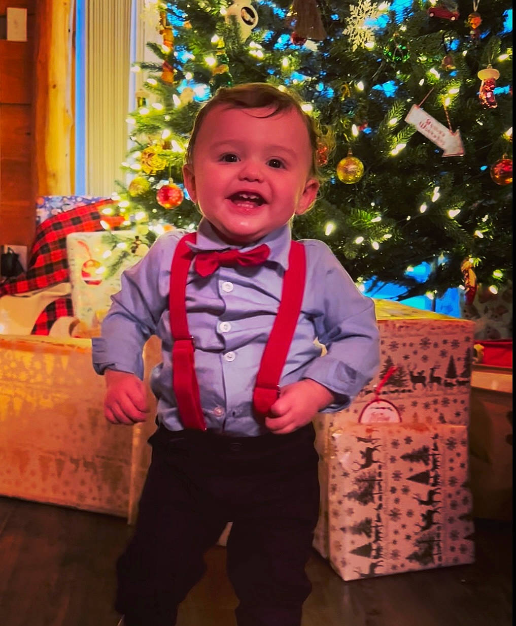 Colten is registered to the contest to win money with this photo: baby_toddler_clothing, child, christmas, christmas_decoration, christmas_eve, christmas_ornament, christmas_tree, event, facial_expression, fun, happy, holiday, holiday_ornament, ornament, person, sleeve, smile, standing, toddler, tree