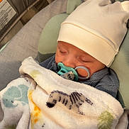 Dayton is registered to the contest to win money with this photo: adorable, animal_print, baby, baby_seat, blanket, child, closeup, comfort, cozy, cute, hat, indoor, infant, nursery, pacifier, peaceful, resting, sleeping, soft_lighting, wearing_clothes
