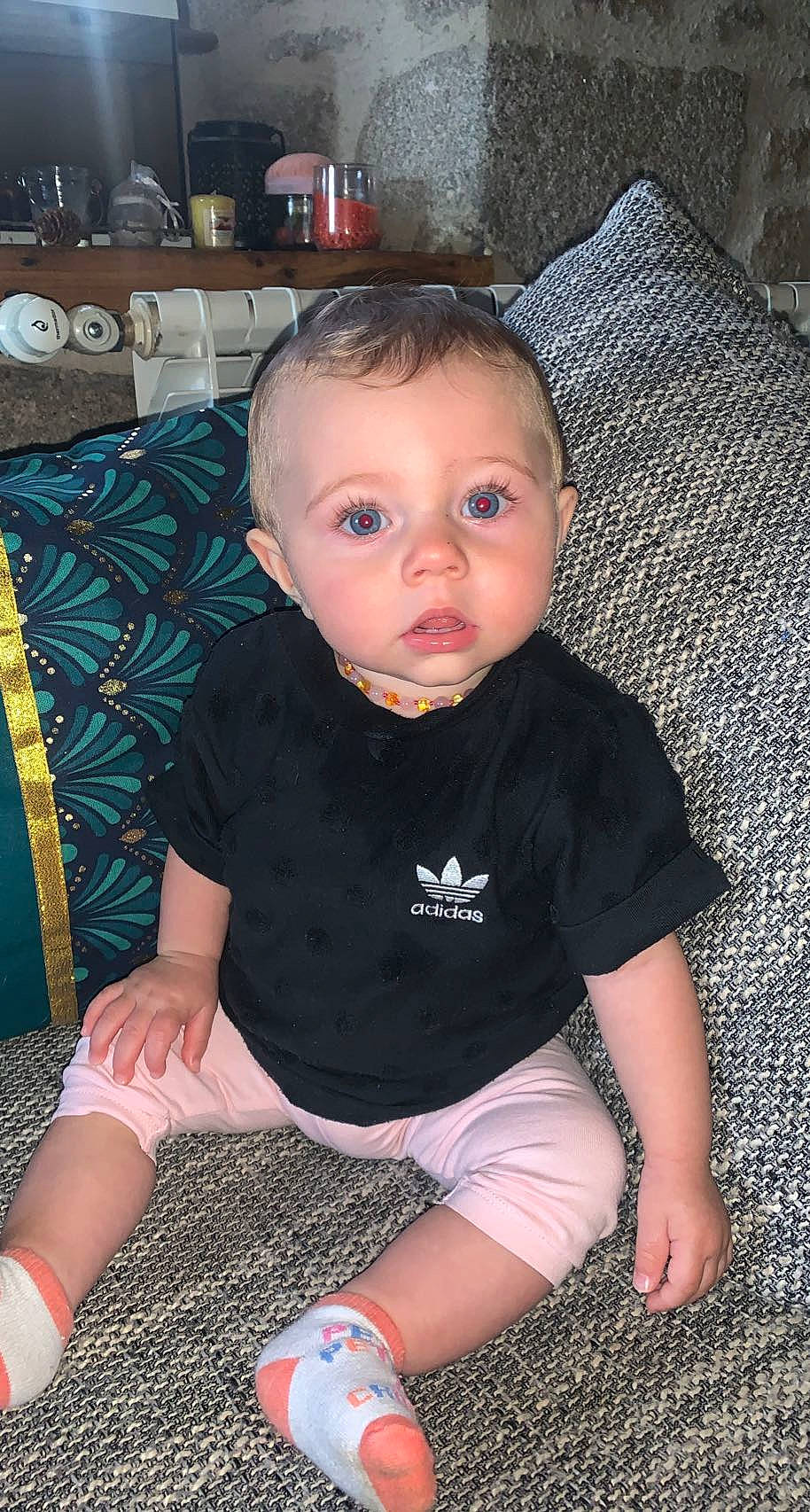 Juliette participe au concours pour gagner de l'argent avec cette photo : baby, baby_toddler_clothing, black, chair, cheek, comfort, couch, finger, flooring, head, human_leg, knee, lap, leg, person, sitting, skin, sleeve, sock, thigh