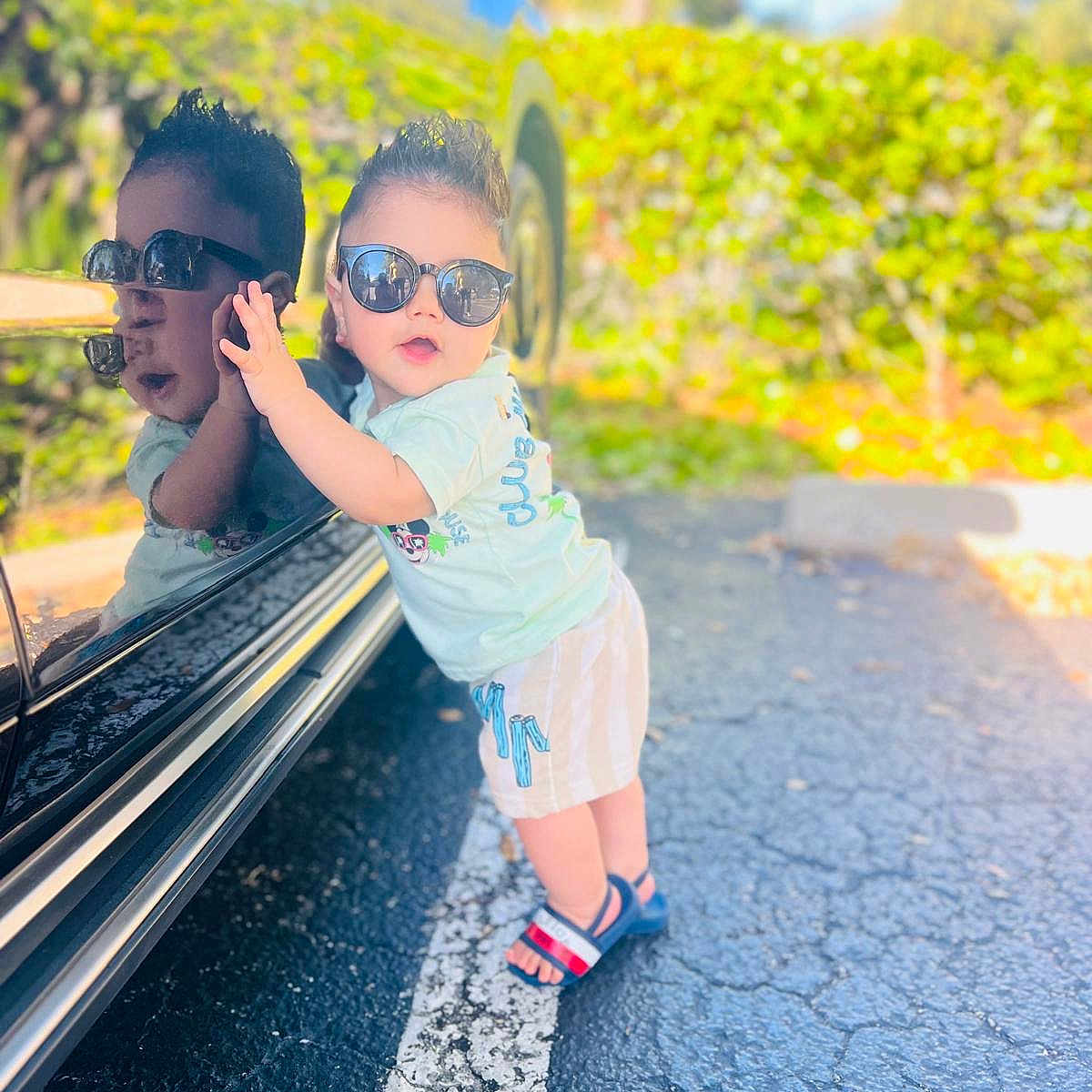 Bryan joined the competition — help win amazing prizes! car, casual, child, clothing, cute, fashion, greenery, happy, outdoor, parking_lot, pavement, person, portrait, reflection, sandals, shorts, summer, sunglasses, sunlight, toddler