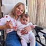 Gabie participe au concours pour gagner de l'argent avec cette photo : woman, baby, glasses, chair, wooden_wall, jeans, white_tights, patterned_dress, holding, smiling, outdoor, casual_clothing, bracelet, ring, baby_shoes, portrait, family, cute, relaxed, daylight