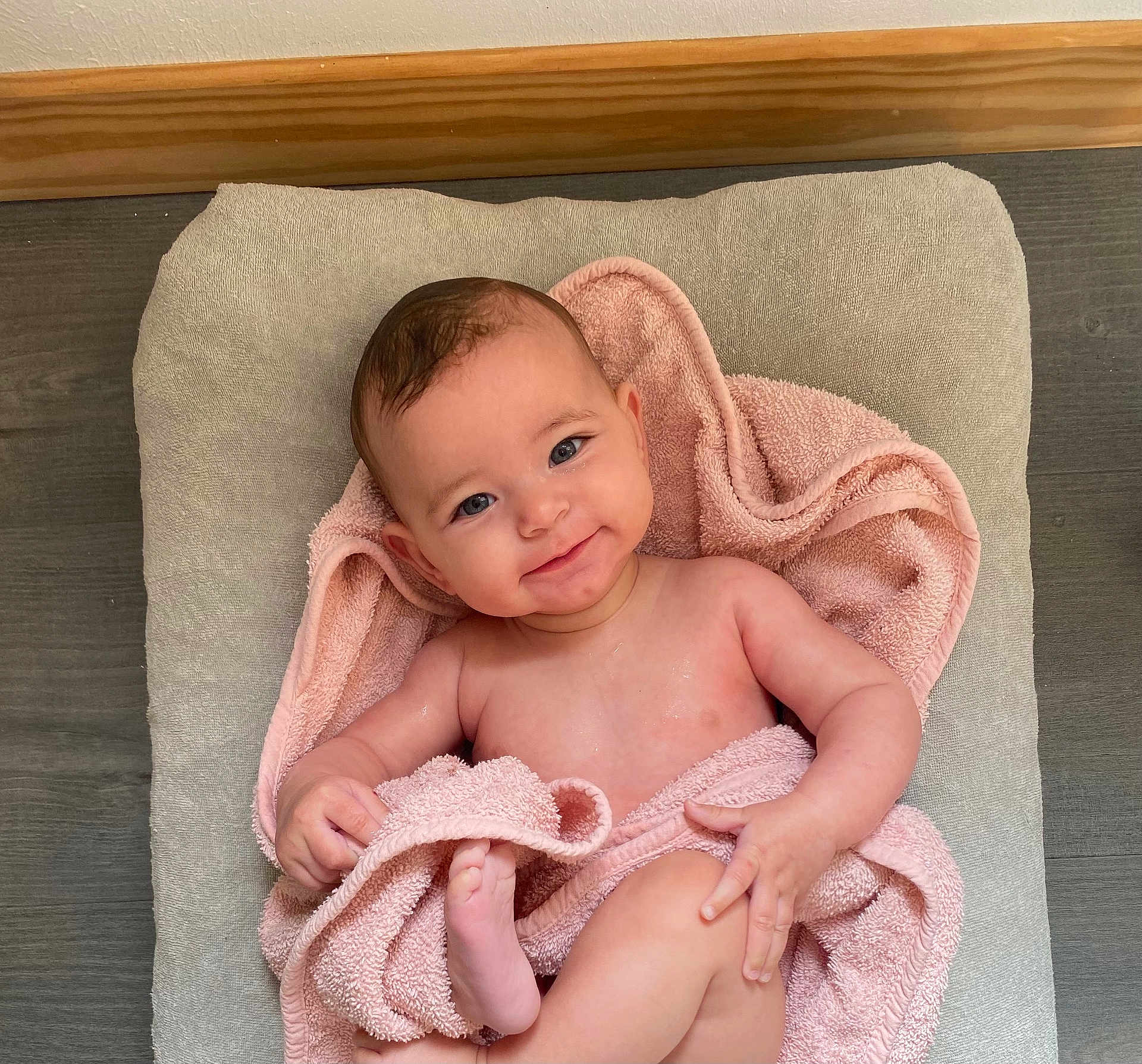 Gabie participe au concours pour gagner de l'argent avec cette photo : baby, child, smiling, towel, pink, skin, face, head, arm, hand, foot, leg, blanket, cushion, wood, floor, indoors, happy, portrait, infant