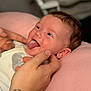 Raya is registered to the contest to win money with this photo: baby, infant, tongue, hands, tattoo, pink_cushion, smiling, face, skin, closeup, person, cute, cute_baby, expression, resting, soft, cozy, indoor, portrait, human