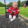 toddler, child, baby, smiling, happy, swing, playground, outdoor, portrait, red_sweater, white_tights, shoes, chains, adult_hand, grass, park, garden, suburban, sky, playground_surface