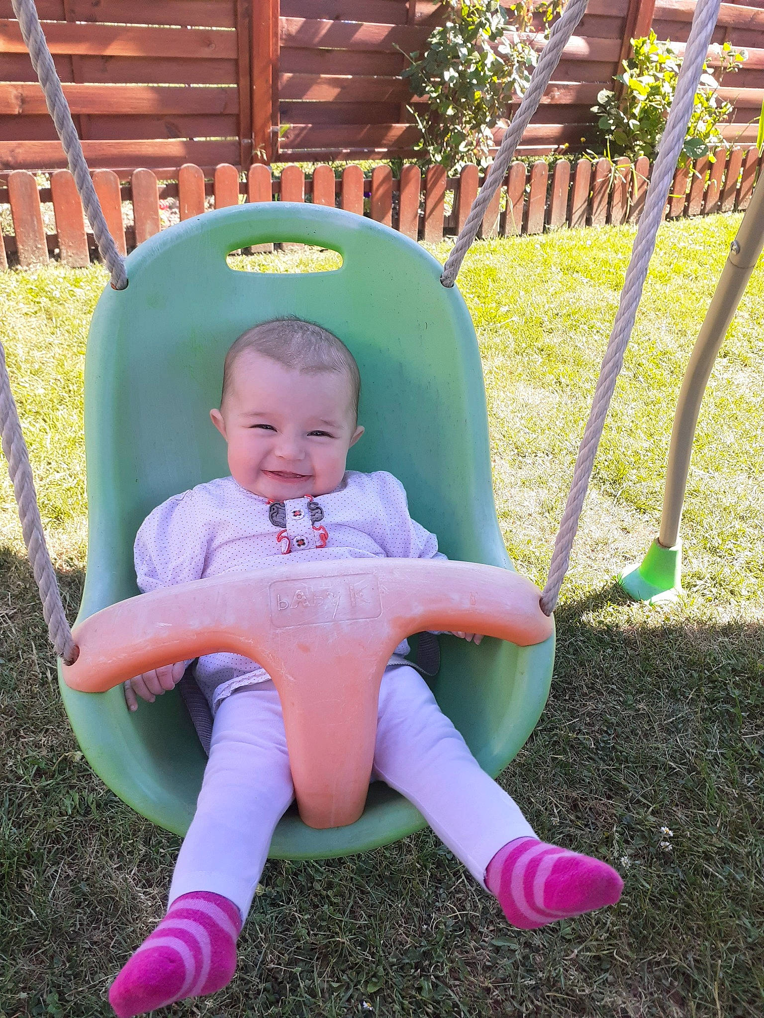 Djenna participe au concours pour gagner de l'argent avec cette photo : baby, child, fun, garden, grass, green, joy, lawn, leisure, outdoor_play_equipment, person, pink, play, product, sitting, swing, toddler, yard