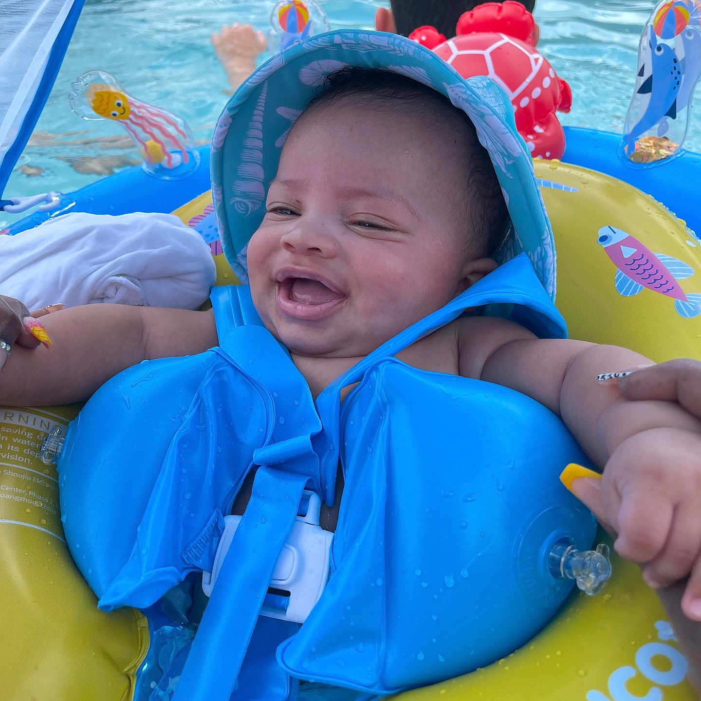 Jyaire joined the competition — help win amazing prizes! adult, baby, blue, child, floatation_device, fun, hand, happy, hat, inflatable, outdoor, person, pool, safety, smiling, summer, swimming, toy, water, yellow