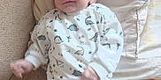 Lowen a rejoint le concours — aidez-le/la à gagner de superbes lots ! baby, infant, smiling, sweater, dinosaur_pattern, pants, couch, pillow, indoor, child, happy, cute, portrait, seated, comfort, young_child, clothing, face, person, home