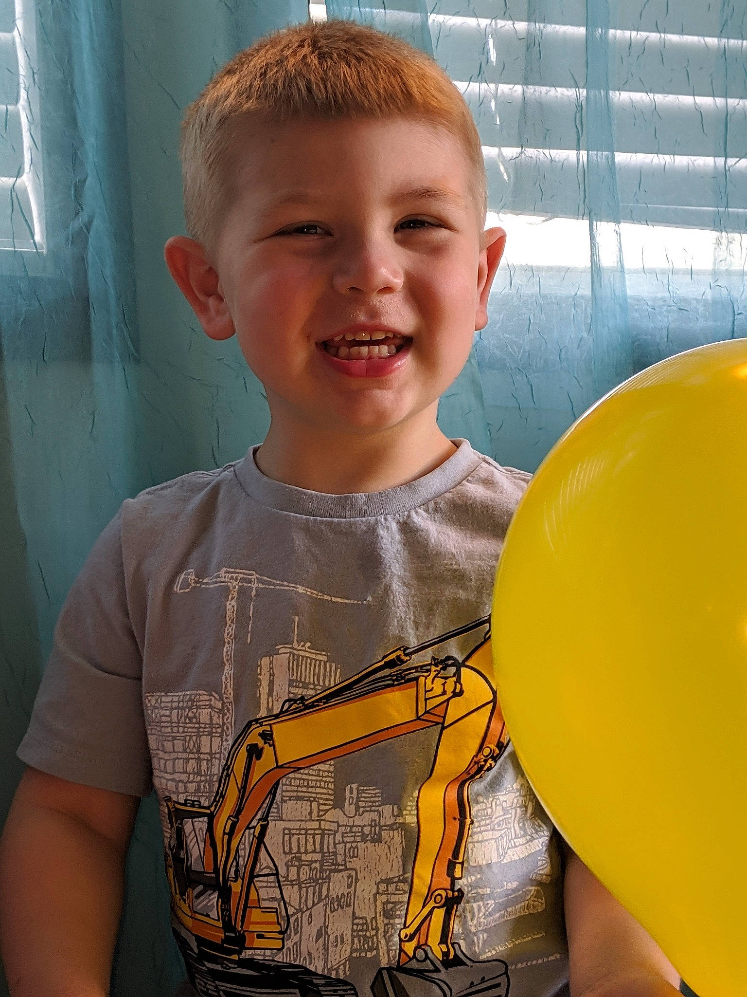 Wyatt is registered to the contest to win money with this photo: arm, balloon, child, joy, male, person, smile, t_shirt, yellow
