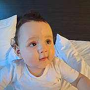 Ewan joined the competition — help win amazing prizes! baby, child, infant, portrait, face, eyes, curious, bed, pillow, bedding, white_clothing, shirt, indoor, bedroom, lying_down, sitting, cozy, warm_lighting, blue_lighting, photography
