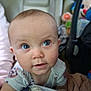 Saige is registered to the contest to win money with this photo: baby, child, infant, face, blue_eyes, curious, soft_blanket, toy, indoors, close_up, cute, person, young_child, apparel, head, skin, expression, sitting, candid, portrait