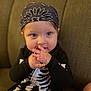 Toby is registered to the contest to win money with this photo: baby, child, costume, skeleton, bandana, black_clothing, couch, indoor, portrait, hands, face, blue_eyes, cute, infant, sitting, clothing, person, toy, expression, young