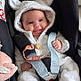 Olivia a rejoint le concours — aidez-le/la à gagner de superbes lots ! baby, child, car_seat, smiling, hooded_jacket, fluffy_clothing, cute, infant, seatbelt, safety, playful, happy, indoors, soft_toys, plush, white_clothing, young_child, face, portrait, cozy