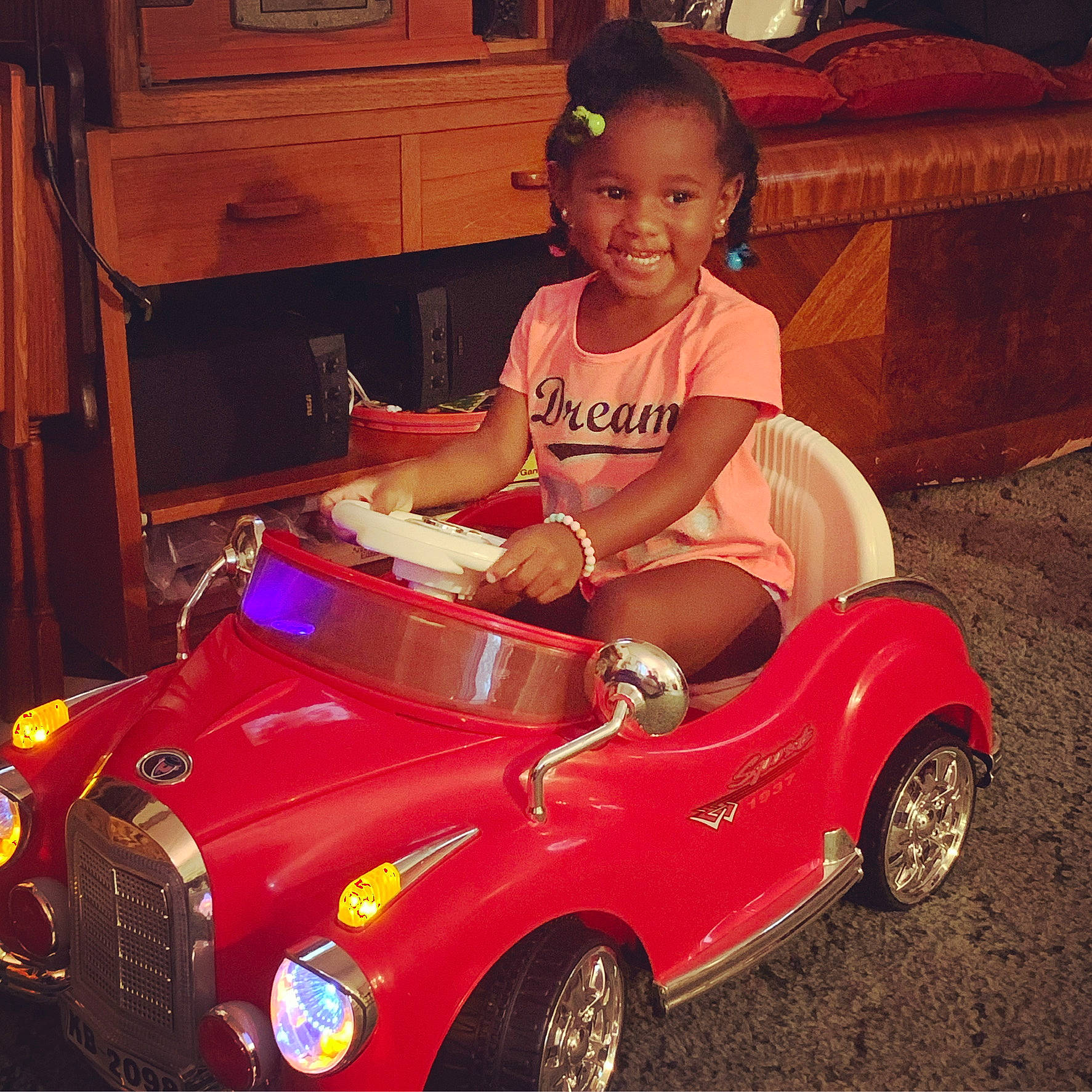 Nayeli joined the competition — help win amazing prizes! automotive_design, automotive_exterior, automotive_lighting, automotive_wheel_system, bumper, cabinetry, car, drawer, happy, headlamp, hood, joy, motor_vehicle, person, riding_toy, smile, television, tire, toddler, toy