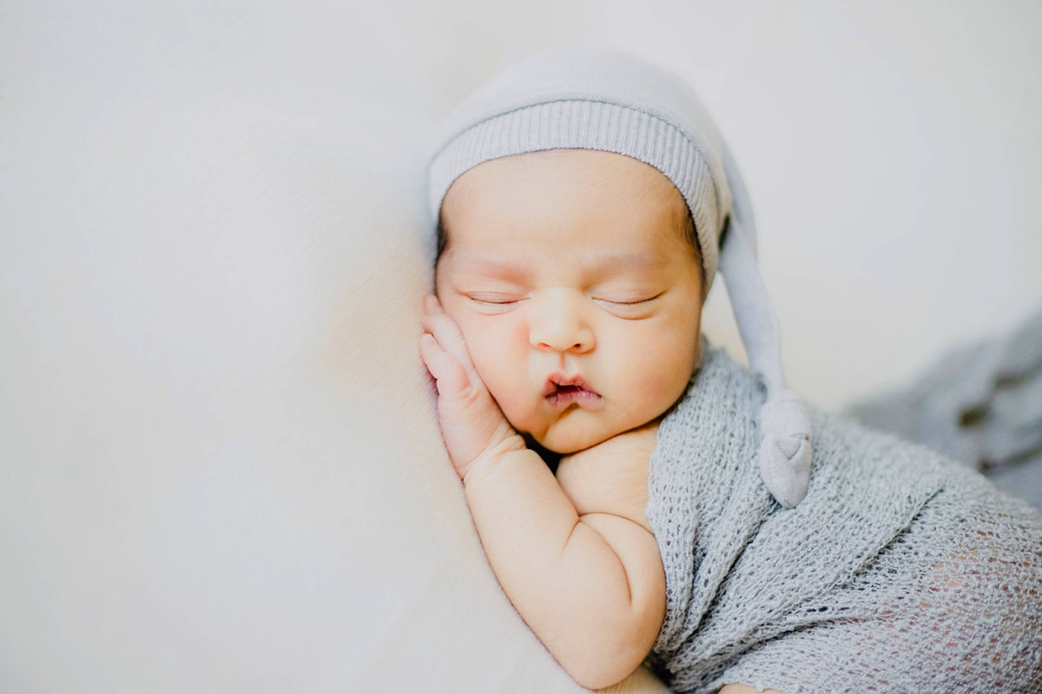 Akira is registered to the contest to win money with this photo: arm, baby, baby_sleeping, baby_toddler_clothing, beanie, cheek, comfort, flash_photography, gesture, grass, happy, headgear, headwear, linens, nail, person, portrait_photography, sitting, skin, sleeve