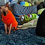 cat, sphynx_cat, sweater, bed, blanket, pillow, headboard, indoor, furniture, patterned_bedspread, decor, plush_toy, blue_light, wall_art, cozy, pet, animal, resting, cute, domestic