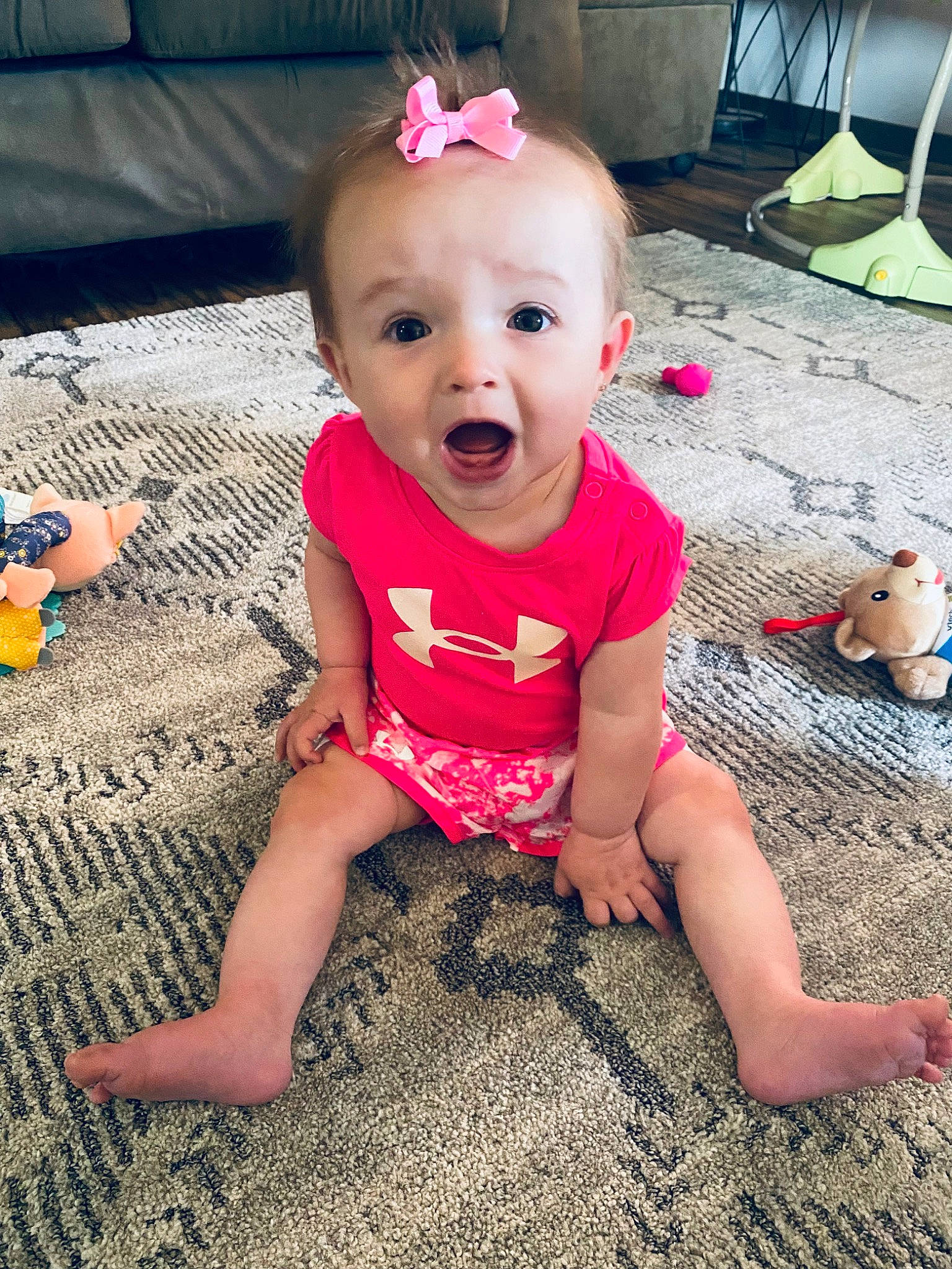 Charlotte is registered to the contest to win money with this photo: baby, baby_toddler_clothing, cheek, child, cool, eye, facial_expression, flooring, grass, happy, head, iris, mammal, person, pink, sitting, skin, sleeve, smile, surprise