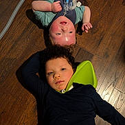 Weston joined the competition — help win amazing prizes! child, children, floor, wooden_floor, lying_down, medical_device, breathing_tube, neck_support, indoor, casual_clothing, portrait, two_people, face, young, relaxed, candid, friendship, healthcare, home, diverse