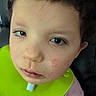 Weston is registered to the contest to win money with this photo: child, closeup, face, curly_hair, red_patches, bib, green_bib, expression, young, indoors, skin_condition, portrait, person, head, sitting, casual, young_child, human, cute, tired