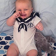 Ryker joined the competition — help win amazing prizes! baby, infant, smiling, sailor_outfit, plush_toy, elephant_plush, blanket, whale_pattern, cute, child, happy, indoors, clothing, soft_toy, toddler, seated, person, portrait, playful, cozy