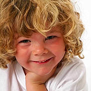 Ashton is registered to the contest to win money with this photo: child, curly_hair, smile, face, portrait, white_shirt, blond, happy, close_up, hand, cheek, cute, young, innocent, person, light_background, skin, blue_eyes, head, expression