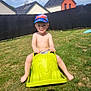 toddler, child, grass, outdoor, toy, plastic_toy, cap, smile, sunny, house, fence, green, play, barefoot, summer, fun, happy, kid, daytime, recreation