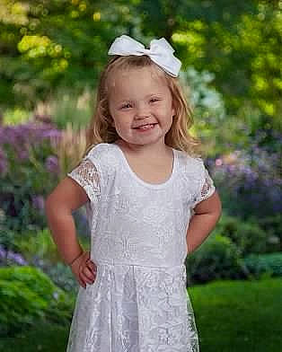 Keegan is registered to the contest to win money with this photo: arm, baby_toddler_clothing, day_dress, dress, eye, face, grass, happy, head, headgear, joy, one_piece_garment, people_in_nature, person, pink, plant, shoulder, sleeve, smile, summer