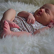 Kasey is registered to the contest to win money with this photo: baby, newborn, sleeping, infant, fluffy_blanket, onesie, peaceful, cute, small_feet, soft, portrait, child, sleep, relaxation, skin, hand, foot, cozy, indoors, rest