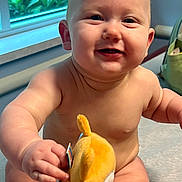Dustyn joined the competition — help win amazing prizes! arm, baby, child, cute, face, greenery, hand, happy, head, indoor, infant, plush_toy, shoulder, sitting, skin, smiling, toy, window, yellow_toy, young