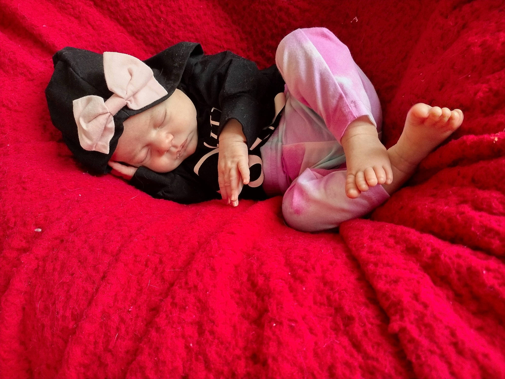 Mazie is registered to the contest to win money with this photo: bedding, carmine, child, comfort, flash_photography, flesh, flooring, foot, fun, fur, grass, headwear, human_leg, linens, magenta, person, petal, pink, room, sitting