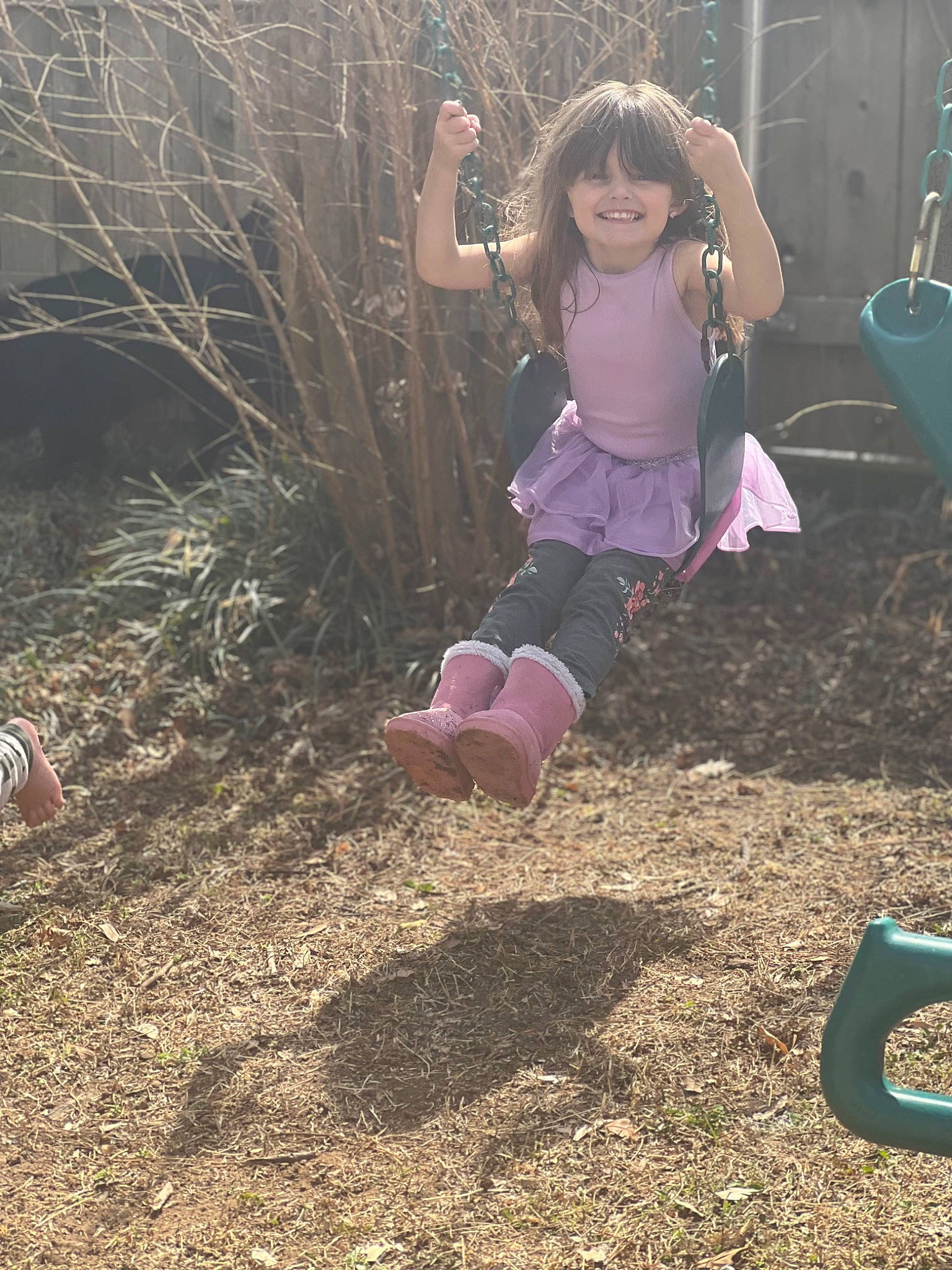 Jordan is registered to the contest to win money with this photo: child, city, fun, grass, happy, joy, landscape, leisure, magenta, outdoor_play_equipment, people_in_nature, person, plant, play, playground, recreation, sitting, smile, soil, swing