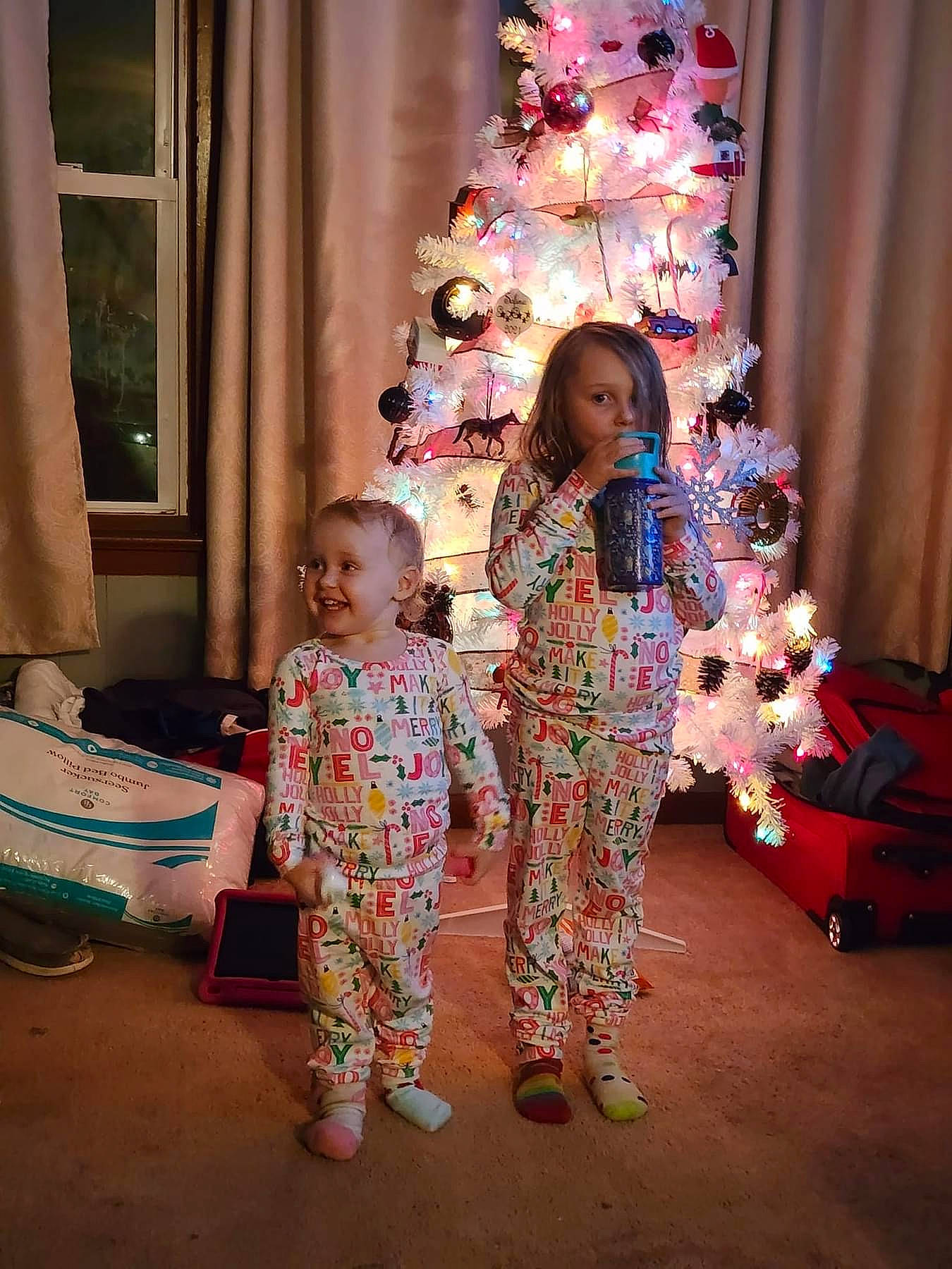 Nalia is registered to the contest to win money with this photo: child, christmas_decoration, christmas_ornament, christmas_tree, curtain, event, fashion, fun, happy, holiday, holiday_ornament, joy, leisure, ornament, person, pink, smile, standing, toddler, tradition