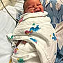 newborn, baby, hospital, blanket, duck_print, crib, nasal_tube, smile, swaddled, infant, bed, medical, cute, peaceful, person, portrait, healthcare, resting, child, indoors