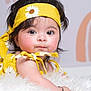 baby, child, infant, yellow_headband, yellow_outfit, daisy_pattern, fluffy_surface, curly_hair, big_eyes, cute, portrait, closeup, soft_lighting, indoor, skin, person, headband, expression, baby_girl, adorable