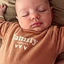 Myla a rejoint le concours — aidez-le/la à gagner de superbes lots ! baby, sleeping, infant, onesie, brown_clothing, cushion, soft_texture, peaceful, face, closed_eyes, child, skin, head, mouth, hand, pale_skin, indoors, portrait, cozy, relaxation