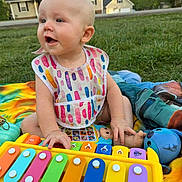 Teresa joined the competition — help win amazing prizes! baby, child, outdoor, grass, toy, xylophone, bib, colorful, blanket, playing, happy, infant, person, summer, nature, house, greenery, fun, cute, sitting