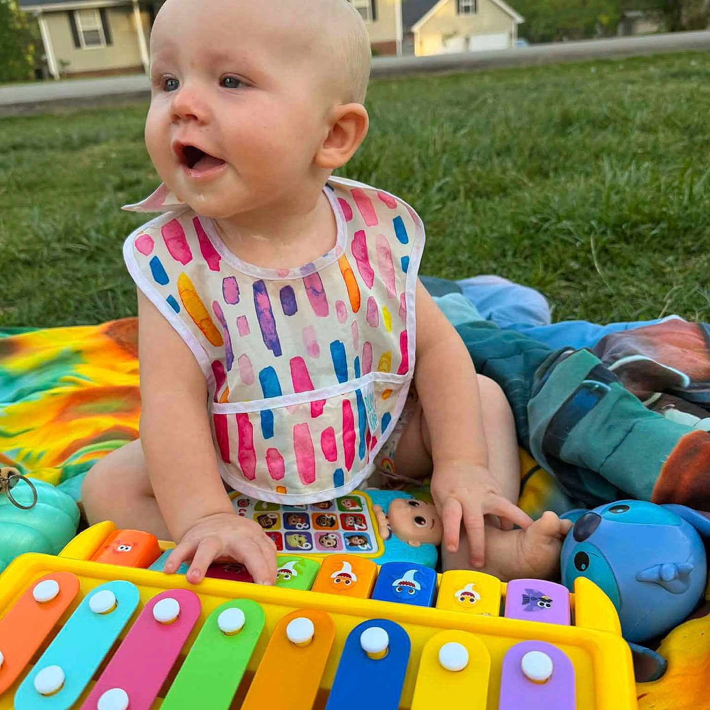 Teresa joined the competition — help win amazing prizes! baby, child, outdoor, grass, toy, xylophone, bib, colorful, blanket, playing, happy, infant, person, summer, nature, house, greenery, fun, cute, sitting