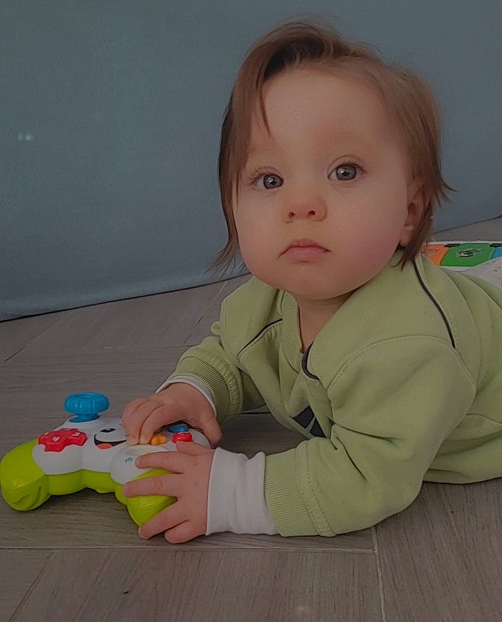 Layana a rejoint le concours — aidez-le/la à gagner de superbes lots ! baby, baby_grabbing_for_something, baby_playing_with_toys, baby_products, baby_toddler_clothing, baby_toys, cheek, child, comfort, floor, flooring, fun, hardwood, person, room, sitting, skin, sleeve, toddler, toy