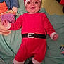baby, black_boots, child, cute, face, festive, happy, hat, holiday, indoors, infant, lying_down, person, play_mat, plush_toys, red_outfit, santa_claus_costume, smiling, soft_surface, toy