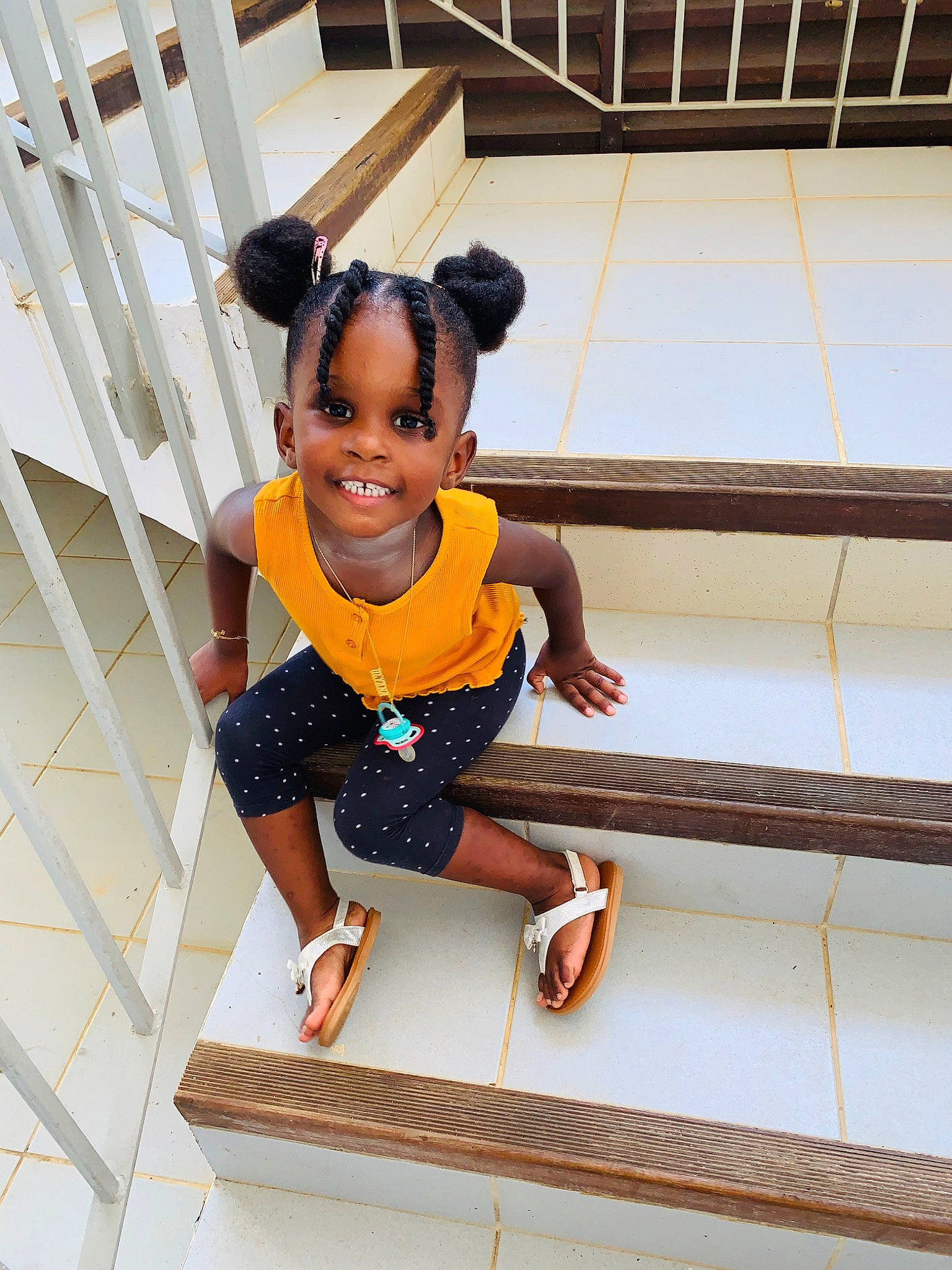 Olyana a rejoint le concours — aidez-le/la à gagner de superbes lots ! baby_toddler_clothing, child, dress, face, flooring, fun, happy, human_leg, joy, leisure, pattern, person, sandal, sitting, sleeve, smile, stairs, street_fashion, thigh, toddler