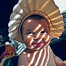 Kali joined the competition — help win amazing prizes! baby, child, face, hat, bowl, light, shadow, striped_light, indoor, playful, grin, window, blinds, skin, cute, portrait, bathtub, water, funny, expression