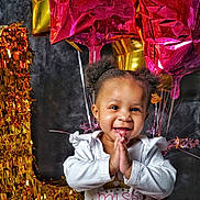 Amaya is registered to the contest to win money with this photo: toddler, child, smiling, happy, birthday, balloons, number_one, celebration, party, gold, pink, clothing, face, hands, hair, indoor, portrait, cute, festive, joyful
