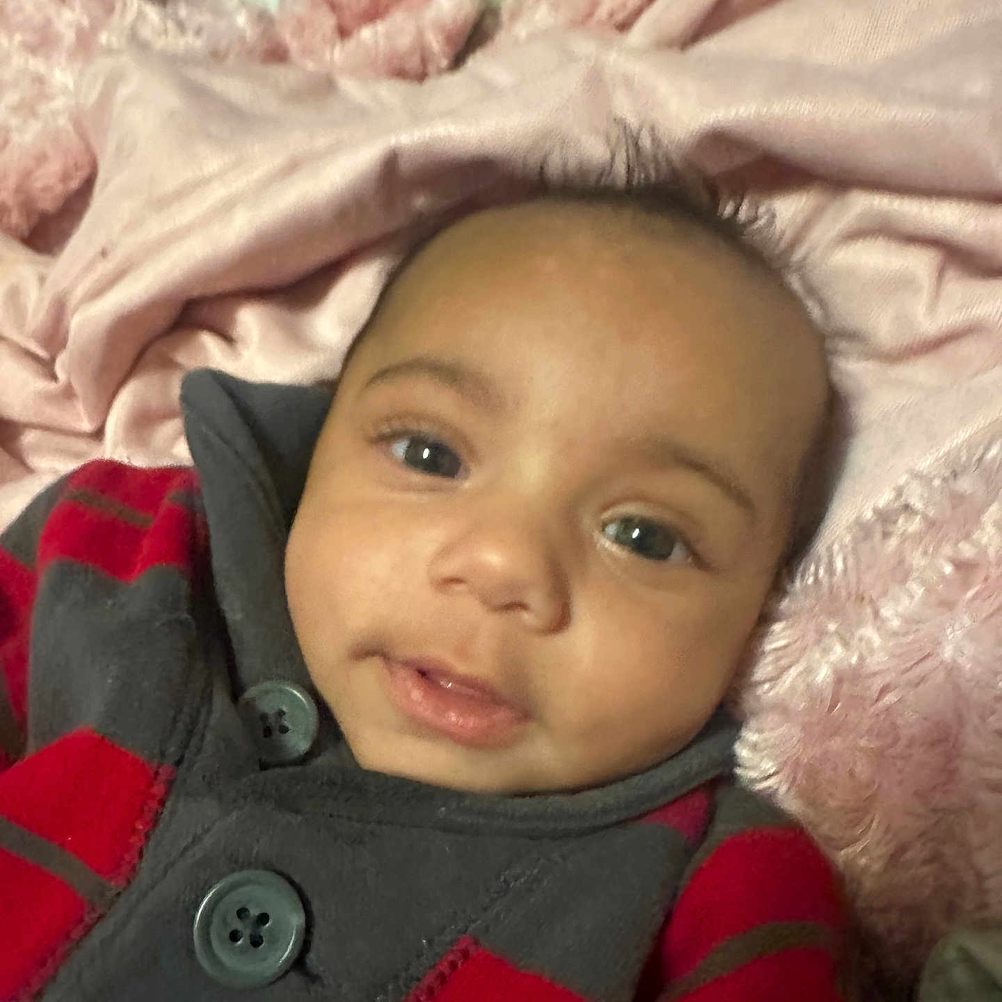 Hudson joined the competition — help win amazing prizes! baby, child, face, portrait, cozy, blanket, red, gray, button, clothing, soft, cute, lying_down, indoor, warm, young, infant, expression, smile, close_up